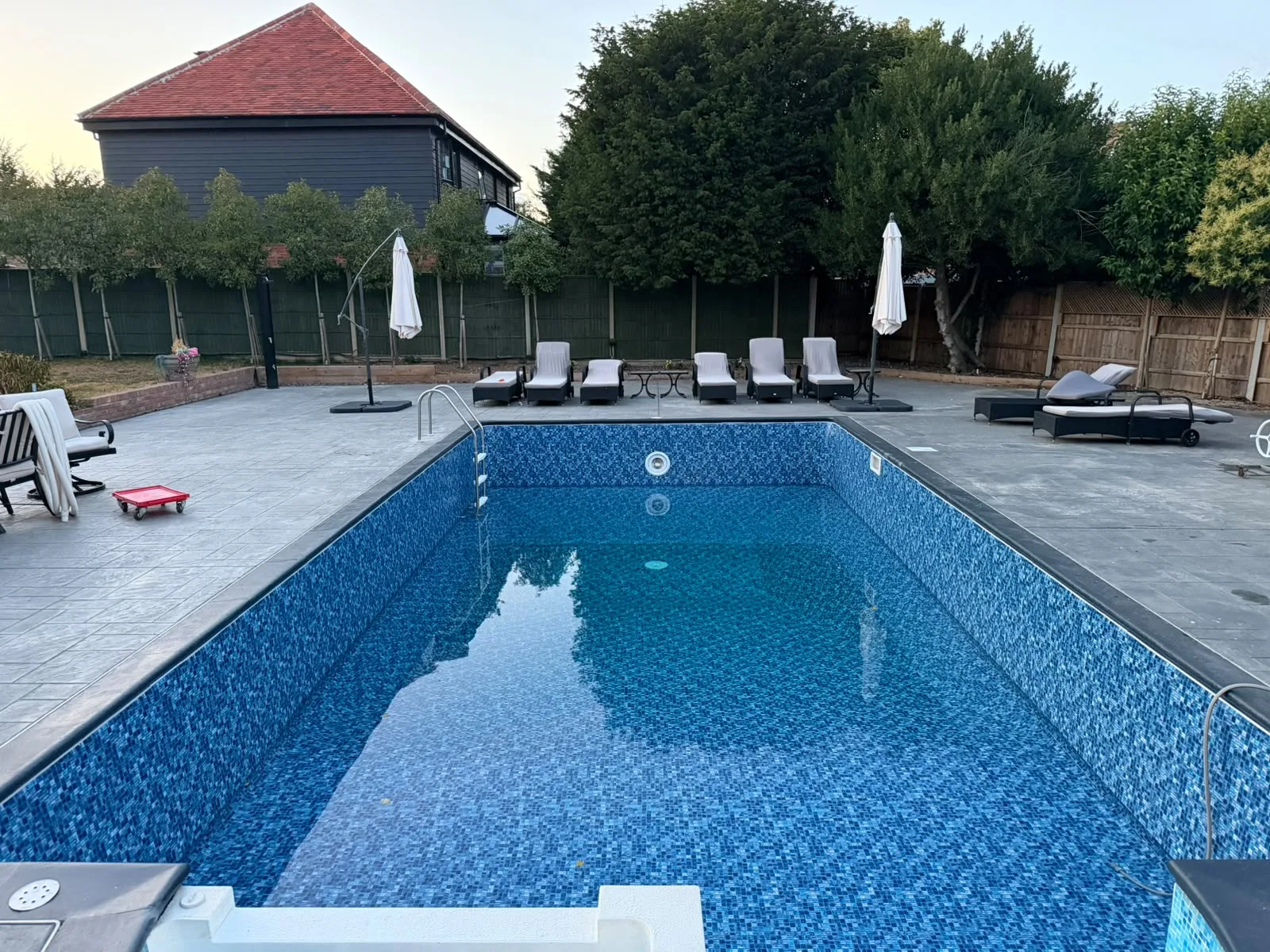 Großer Außenpool mit blauer Mosaikfolie aus einem abgeschlossenen Projekt von Oasis Pool Renovations